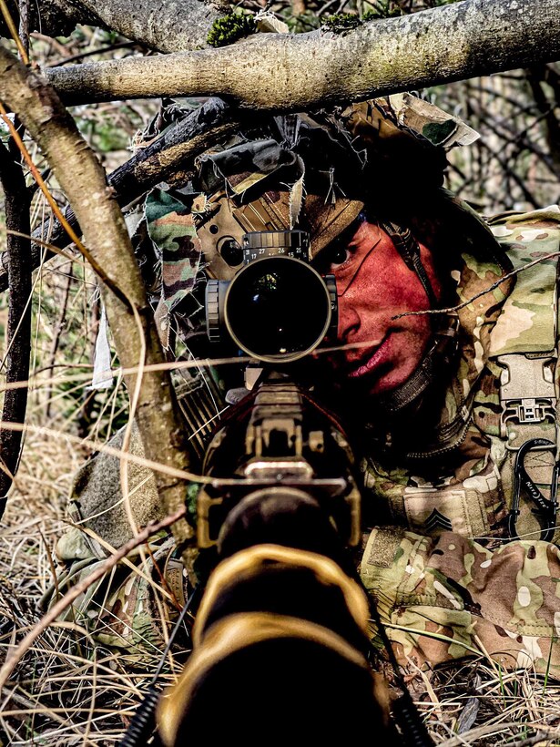 A soldier sites a rifle.