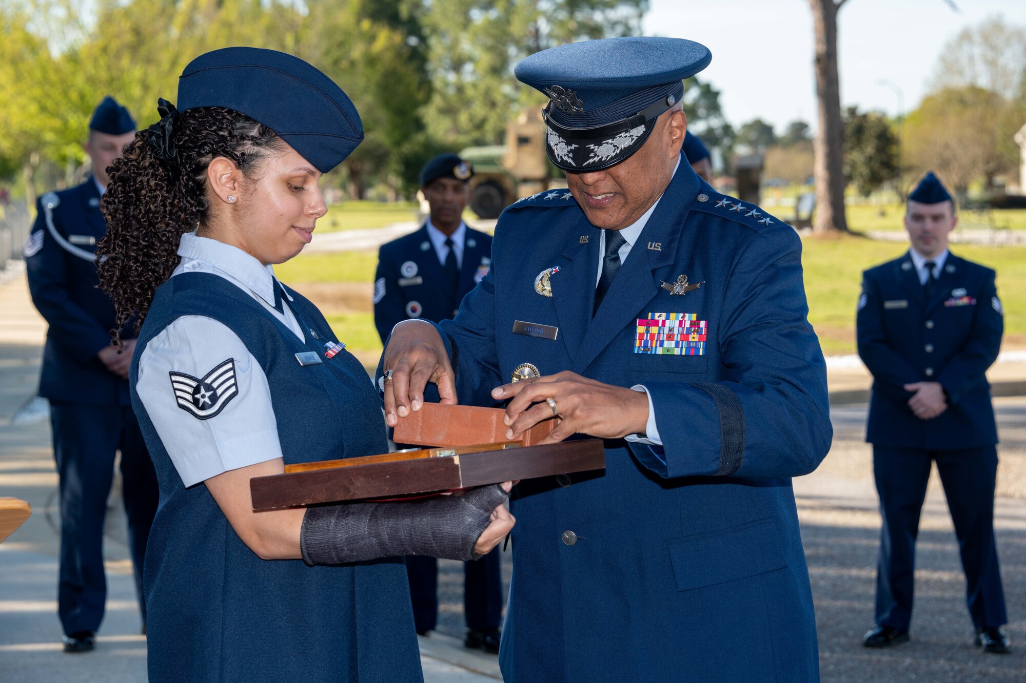 Staff Sgt. Khandi Wagner presents a brick to Gen. Anthony J. Cotton, Commander, U.S. Air Force Global Strike Command and Commander, Air Forces Strategic-Air, U.S. Strategic Command, to be placed at the Enlisted Heritage Research Institute, Apr. 1, 2022. Cotton was honored for his support for the enlisted corps