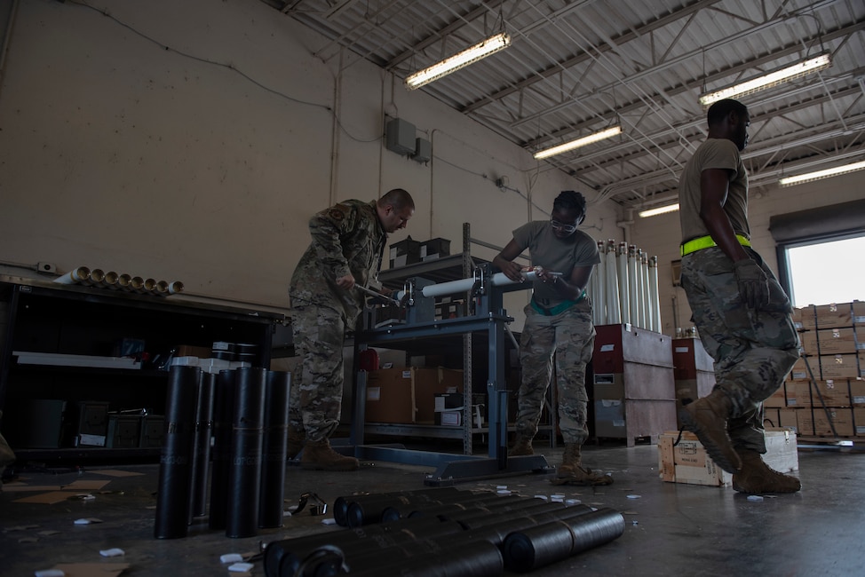 A photo of three people working in a workshop.