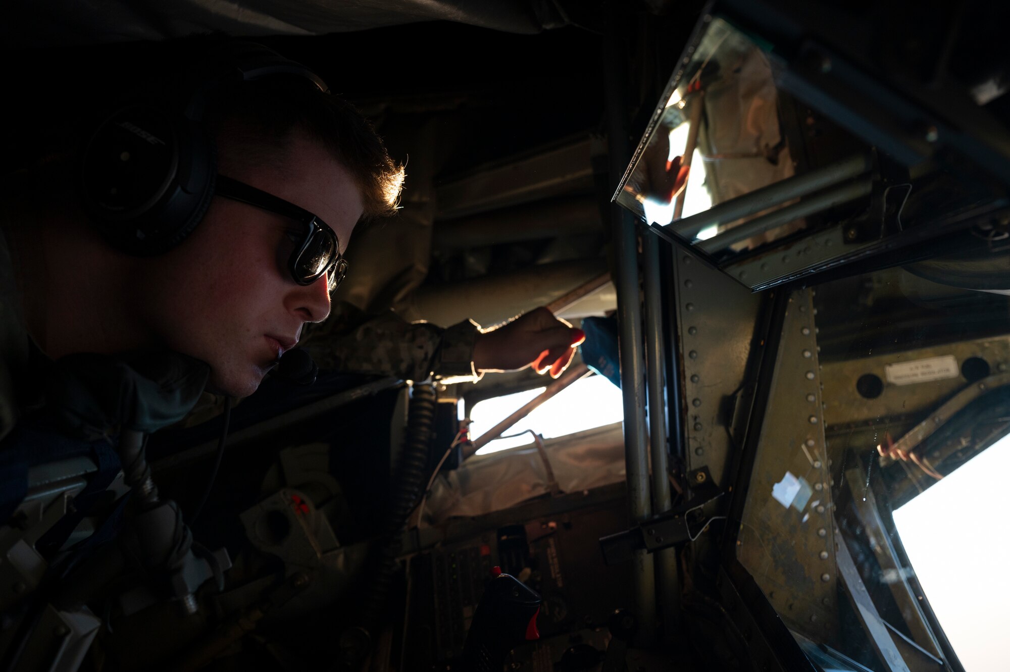 U.S. Air Force Airman 1st Class Dillan Stewart, an in-flight refueling specialist assigned to the 50th Expeditionary Air Refueling Squadron, scans the horizon from a U.S. Air Force KC-135 Stratotanker