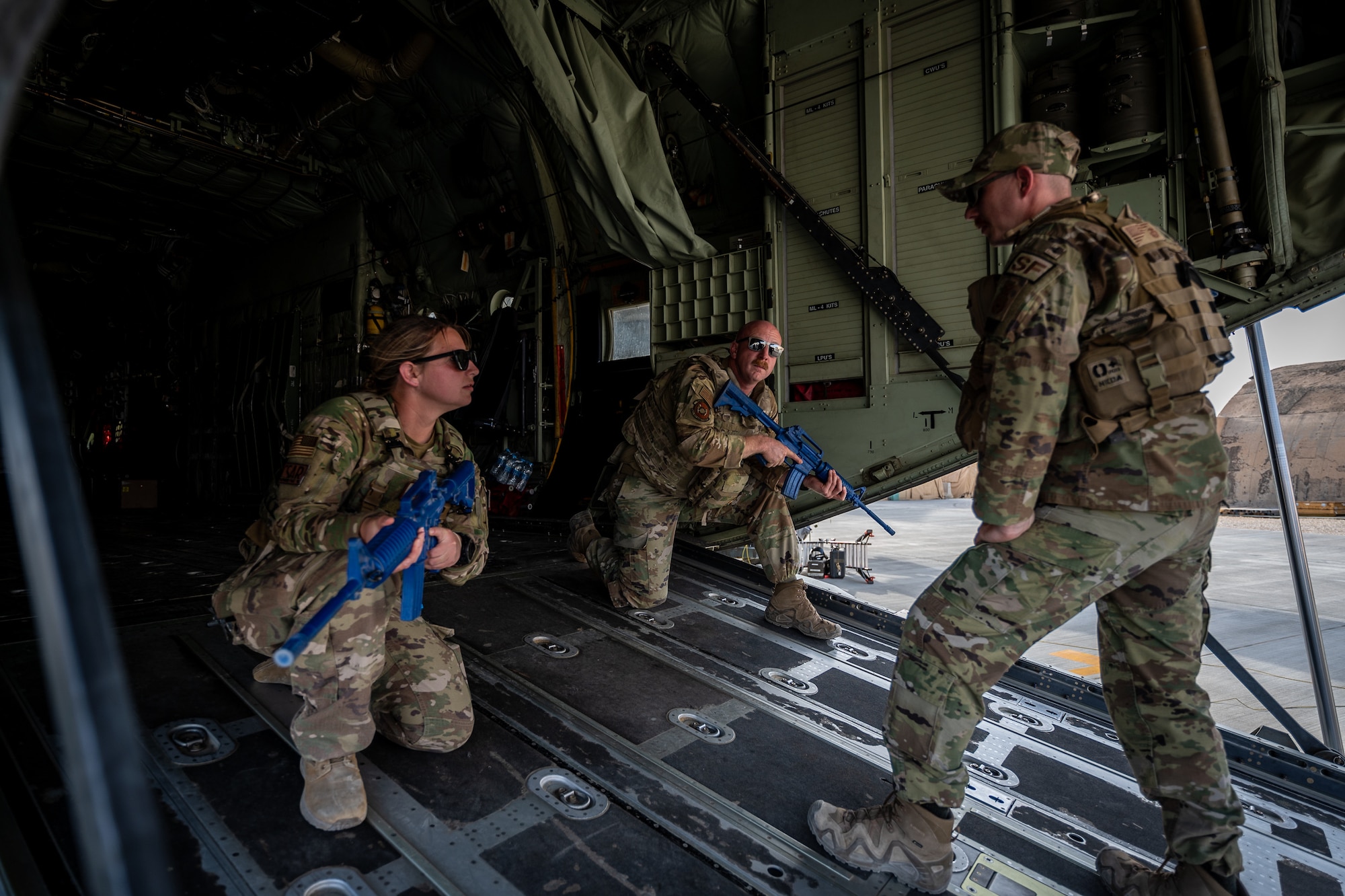 Staff Sgt. Matthew Brown, 332d Expeditionary Security Forces Squadron response force member, instructs First Lieutenant Colleen Sullivan, 801st Expeditionary Maintenance Squadron maintenance officer in charge, and Master Sgt. David Dalton, 801st EMXS production superintendent, on aircraft defense tactics during airfield security operations training led by the 332d Expeditionary Security Forces Squadron at an undisclosed location in Southwest Asia, April 5, 2022. The training focused on small team perimeter security, personnel placement for aircraft defense, and basic defense postures. (U.S. Air Force photo by Master Sgt. Christopher Parr)