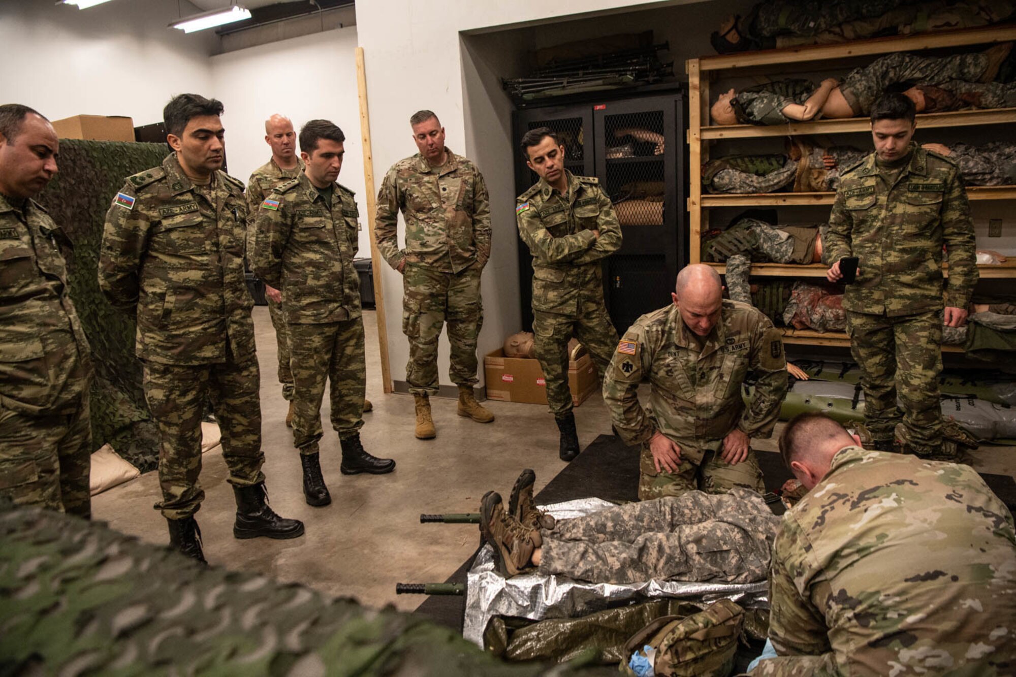 Soldiers simulate first aid treatment on mannequin