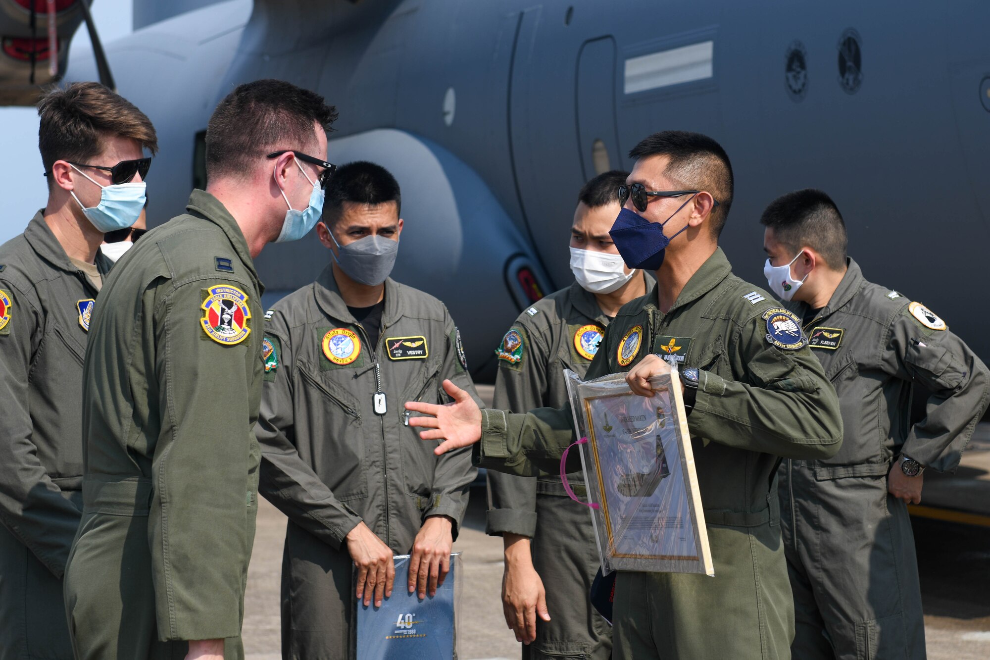Pilots exchange gifts outside of a C-130J
