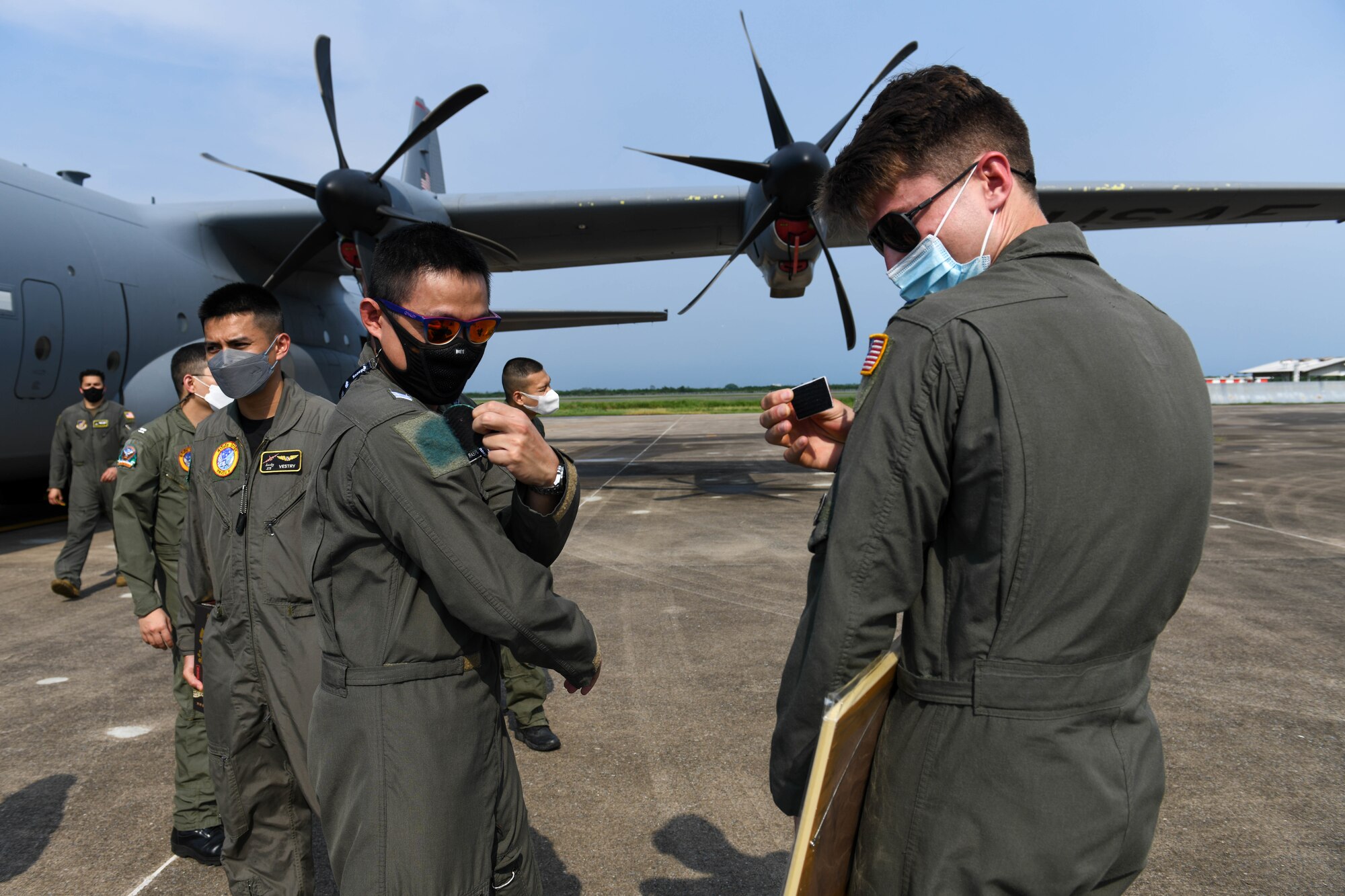Pilots exchange patches outside of a C-130J