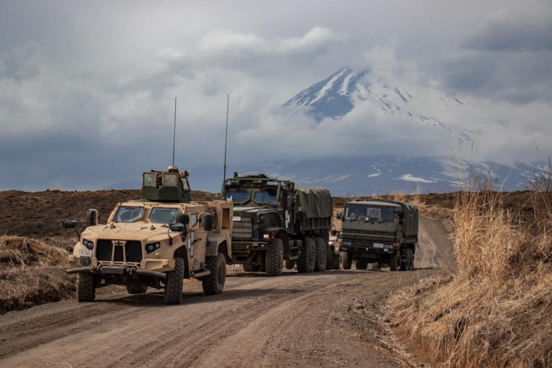 U.S. Marines with Combat Logistics Battalion 31 (CLB), 31st Marine Expeditionary Unit, and Japanese soldiers with the 1st Amphibious Rapid Deployment Regiment conduct a convoy with a Marine Corps joint light tactical vehicle and two medium tactical vehicle replacement trucks, and a Japanese Toyota Type 73 medium truck and two Type 73 Kogata light utility vehicles for a company-level training exercise on Combined Arms Training Center Camp Fuji, Shizuoka Prefecture, Japan, Mar. 17, 2022.