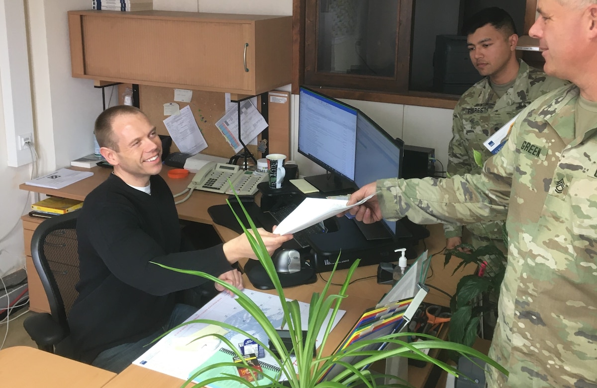 Thomas Ertl, a supply technician who works at the Regional Supply Support Activity’s front desk, assists a couple of Soldiers with their approved walk-up orders. The RSSA, which belongs to the Supply and Services Directorate, Logistics Readiness Center Bavaria, 405th Army Field Support Brigade, has a warehouse with 7,000 items currently in stock. Pictured here, Ertl hands over an approved order to a Soldier for replacement batteries, oil and lubricants, office supplies, and repair parts. (U.S. Army courtesy photo)
