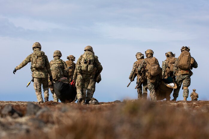 U.S. Marines and Sailors assigned to 22nd Marine Expeditionary Unit and Royal Marine Commandos assigned to M Company, 42 Commando Royal Marines move simulated casualties during a tactical recovery of aircraft and personnel exercise in support of Northern Viking 2022 on Keflavik Airbase, Iceland, April 8, 2022. Northern Viking 22 strengthens interoperability and force readiness between the U.S., Iceland and Allied nations, enabling multi-domain command and control of joint and coalition forces in the defense of Iceland and Sea Lines of Communication in the Greenland, Iceland, United Kingdom (GIUK) gap. (U.S. Marine Corps photo by Cpl. Yvonna Guyette)