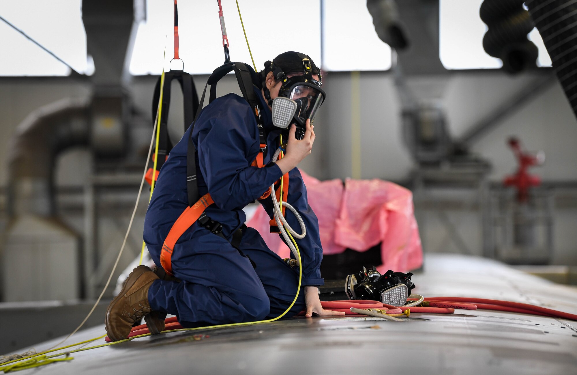 U.S. Air Force Airman 1st Class Katherine Mercado-Ramos, 86th Maintenance Squadron field systems journeyman, performs the duties of an attendant during an annual aircraft fuel tank extraction exercise at Ramstein Air Base, Germany, April 6, 2022. An attendant ensures that the entrant, who is a qualified Airman to perform maintenance inside the fuel tank, is responsive while fixing an issue with the aircraft fuel tank. (U.S. Air Force photo by Airman 1st Class Jared Lovett)