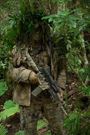 U.S. Marine Corps Staff Sgt. Mathew Kearney (left), chief instructor at the Jungle Warfare Training Center (JWTC), 1st Lt. Sargon II Bebla (center), platoon commander, and Staff Sgt. Brian Giera (right), platoon sergeant, with Battalion Landing Team (BLT) 1/5, 31st Marine Expeditionary Unit (MEU), observe stalking lanes at the JWTC in Okinawa, Japan, Jan. 8, 2022. Scout snipers play an integral part in the Stand in Force Concept operating as the eyes and ears of the ground force commander, allowing for a more efficient decision making process.