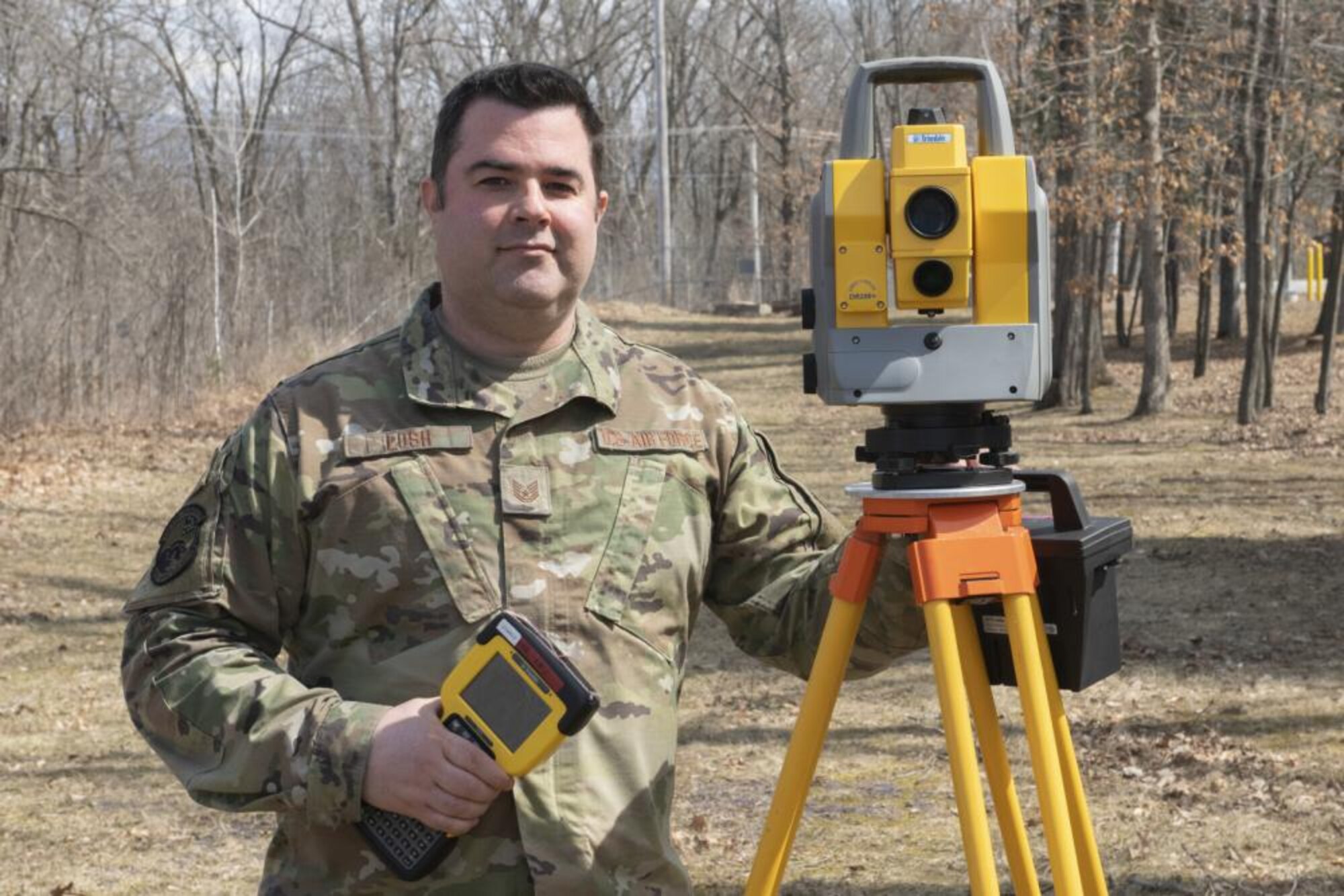 Photograph of Tech. Sgt. Normal Losh standing with Civil Engineering equipment outside at the Vermont Air National Guard base in South Burlington, Vermont.,