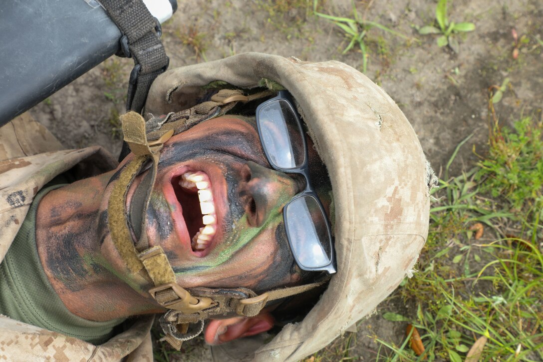 A closeup of a Marine's face as he grimaces.