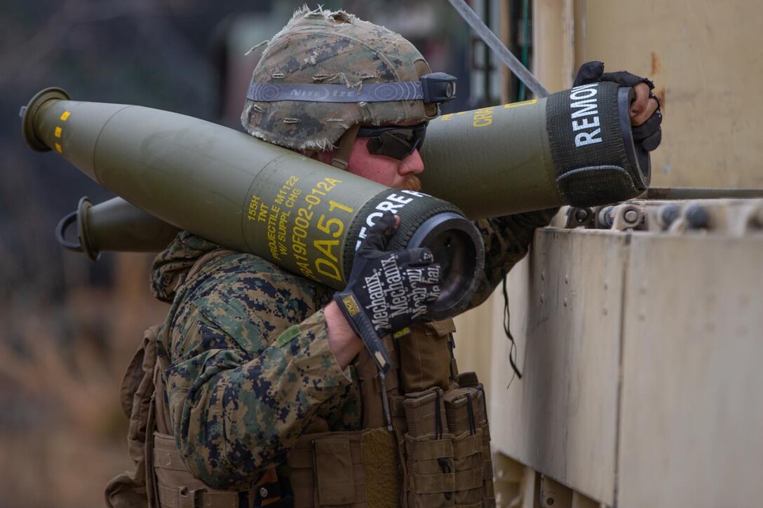 A U.S. Marine with Echo Battery, 2d Battalion, 10th Marine Regiment, 2d Marine Division, carries 155mm artillery shells during Exercise Rolling Thunder 22-2 on Fort Bragg, North Carolina, March 30, 2022. This exercise is a 10th Marines-led live fire artillery event that tested the unit’s abilities to operate in a simulated littoral environment against a peer threat in a dynamic and multi-domain scenario. (U.S. Marine Corps photo by Lance Cpl. Ryan Ramsammy)