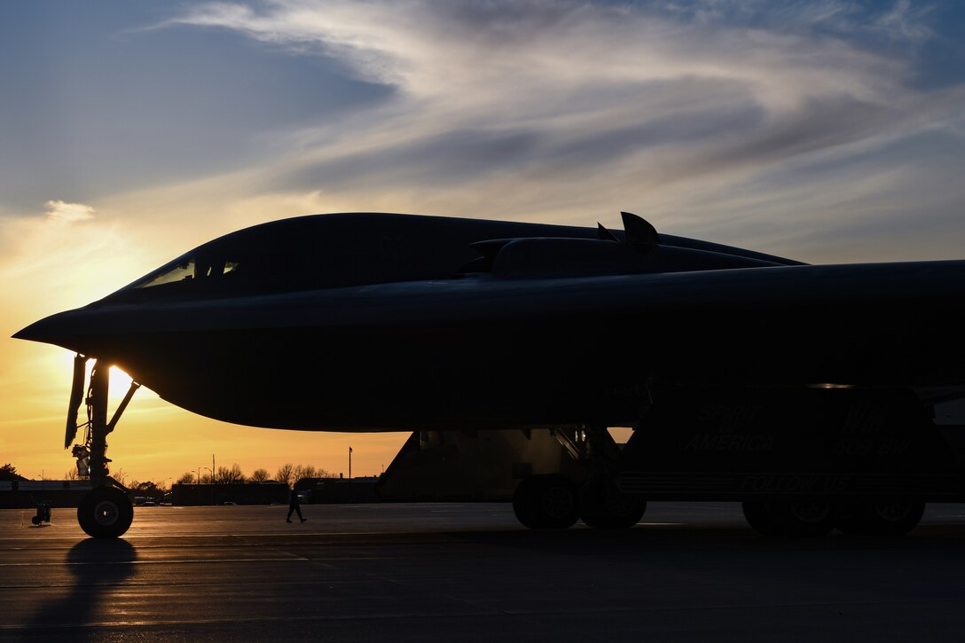 A large aircraft sits on the tarmac at twilight.