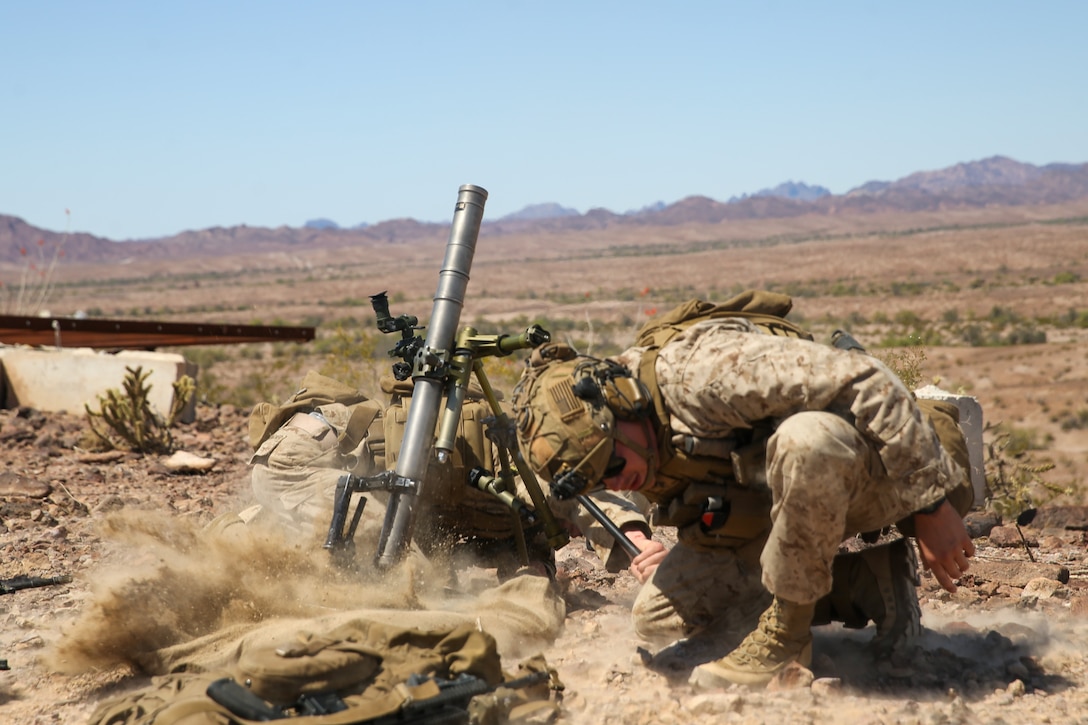 U.S. Marine Corps Lance Cpl. Eduardo Garrido, a native of Miami and Lance Cpl. Stacee Fehrenbacher, a native of New Orleans, both mortarman with 1st Battalion, 2d Marine Regiment, 2d Marine Division (MARDIV), fires a 60mm mortar during Weapons and Tactics Instructor (WTI) course on Marine Corps Air Station Yuma, Arizona, March 30, 2022. WTI is a seven-week training event, hosted by Marine Aviation Weapons and Tactics Squadron One (MAWTS-1), which emphasizes the development of small task-organized unit experimentation across all warfighting functions, as well as enhance the battalion's ability to conduct command and control, fire-support planning, intelligence functions, and logistical support to distributed company level operations. This exercise continues support of 2d MARDIV's experimental battalion's assessment and mission essential task list-based pre-deployment training progression. (U.S. Marine Corps photo by Pfc. Sarah Pysher)