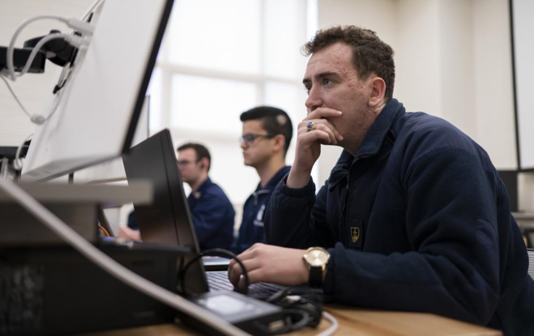 A U.S. Coast Guard Academy cadet, a member of the Academy's cyber team looks at his computer while participating in the National Security Agency's (NSA) annual cyber exercise (NCX), here, Mar. 31, 2022. The Academy's cyber team won third place out of 12 total teams. (U.S. Coast Guard photo by Petty Officer 3rd Class Matthew Abban)