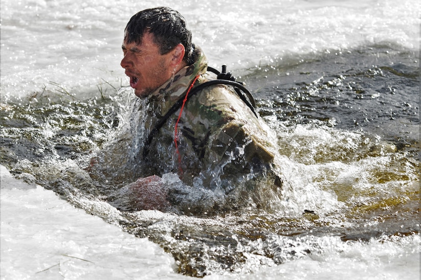A man surfaces in a frozen lake.