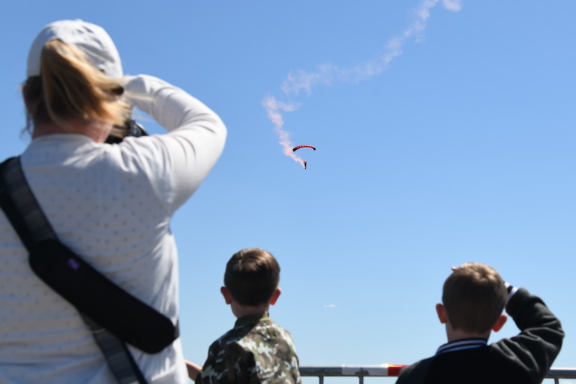 A family observes the U.S. Army Black Daggers Parachute Demonstration Team at the Titans of Flight Air Expo, Joint Base Charleston, South Carolina, April 7, 2022.