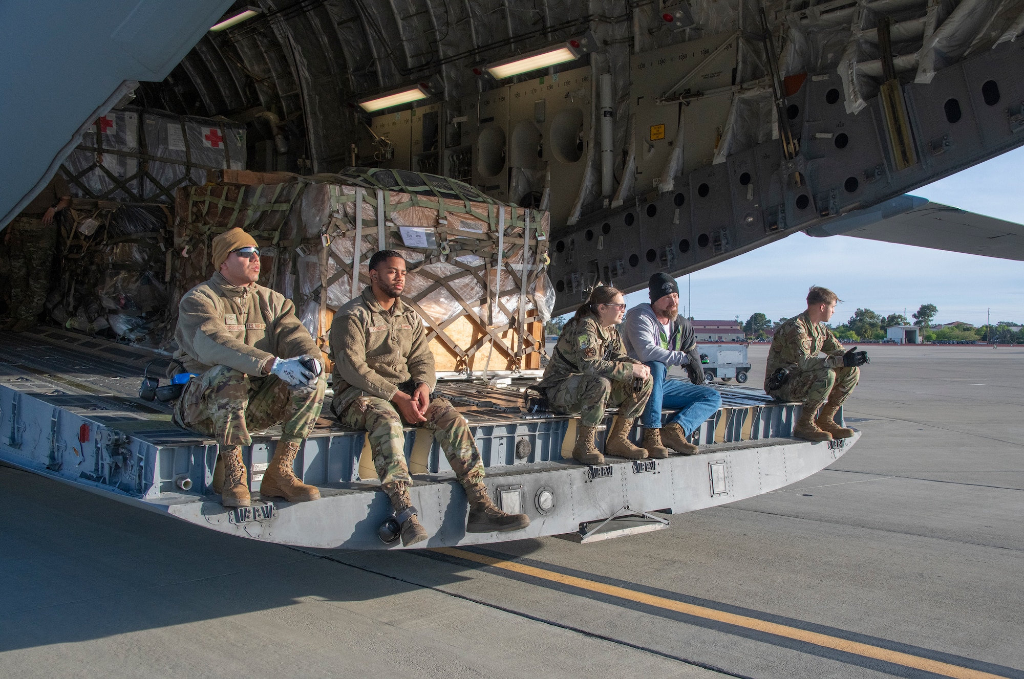 U.S. Airmen assigned to the 60th Aerial Port Squadron wait for the next load of cargo to be delivered during readiness exercise Roundel Perun 22-01, Travis Air Force Base, California, April 10, 2022. The base exercise was designed to enhance the capabilities of multiple squadrons in responding to possible real-world scenarios. (U.S. Air Force photo by Heide Couch)
