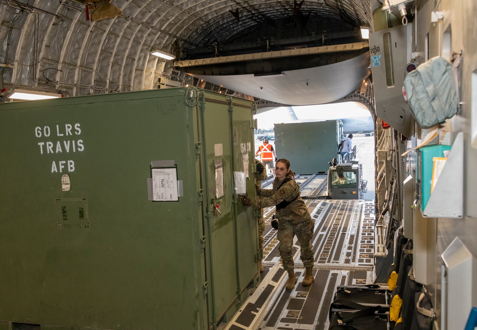 an airman pushes a pallet on to an airplane