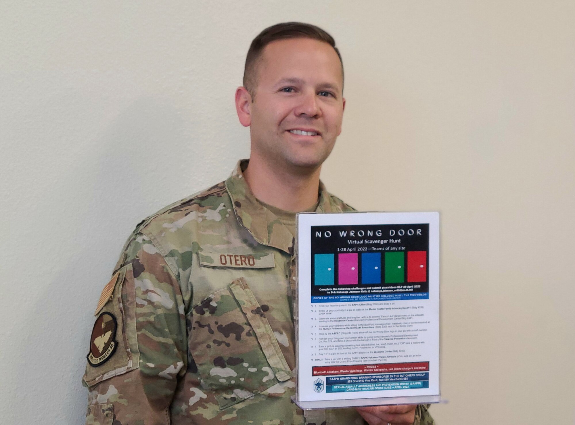 A photo of an Airmen holding a sign.