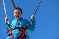 A child swings inflatable bungie trampoline at the Titans of Flight Air Expo, Joint Base Charleston, South Carolina, April 10 2022.