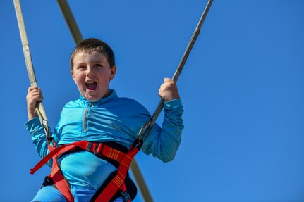 A child swings inflatable bungie trampoline at the Titans of Flight Air Expo, Joint Base Charleston, South Carolina, April 10 2022.