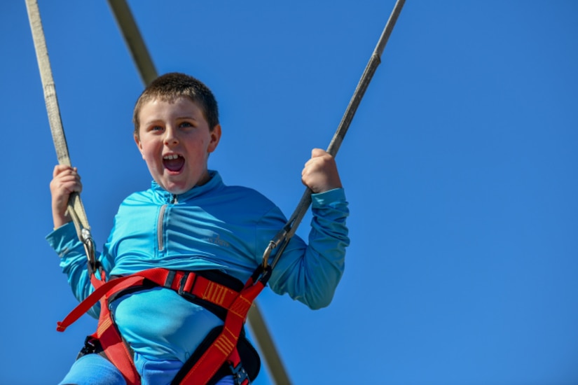 A child swings inflatable bungie trampoline at the Titans of Flight Air Expo, Joint Base Charleston, South Carolina, April 10 2022.