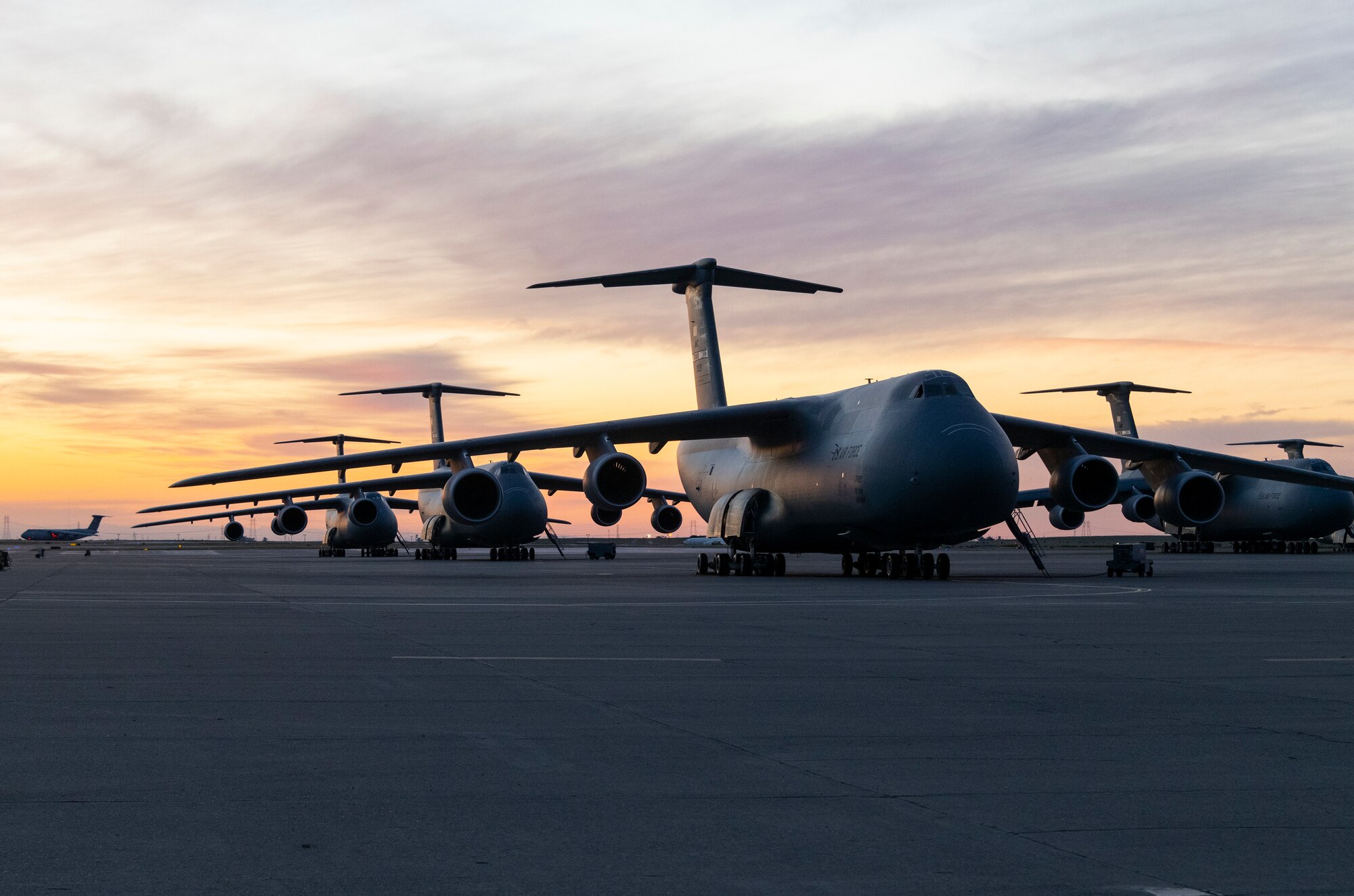 airplanes sit on the flight line during sunrise