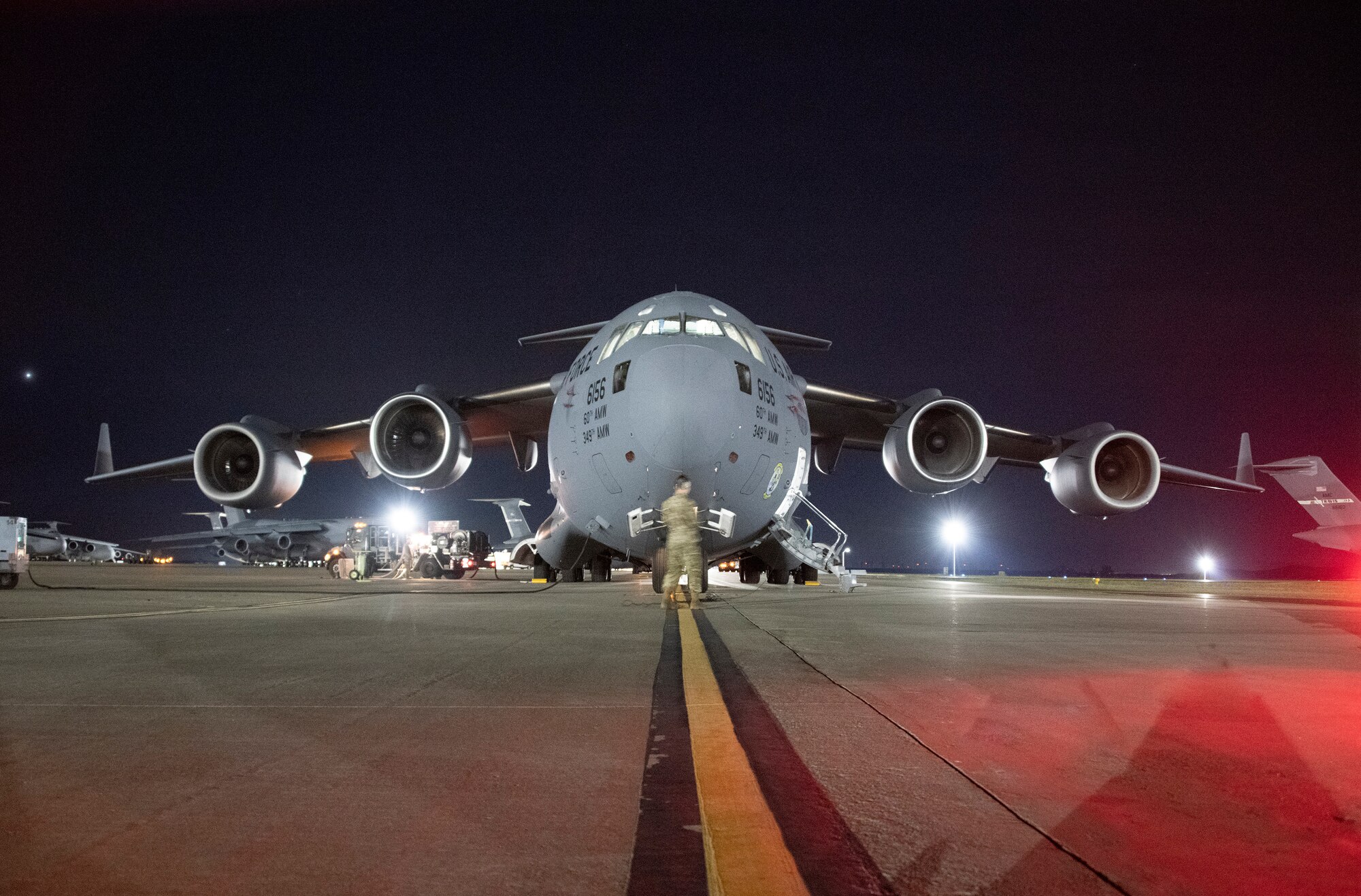 A U.S. Airman assigned to the 60th Air Mobility Wing is part of a pre-flight team servicing a C-17 Globemaster III prior to take off at Travis Air Force Base, California, April 10, 2022. Airmen from multiple squadrons participated in exercise Roundel Perun 22-01, testing the ability to employ rapid mobility capabilities during possible real-world scenarios. (U.S. Air Force photo by Heide Couch)