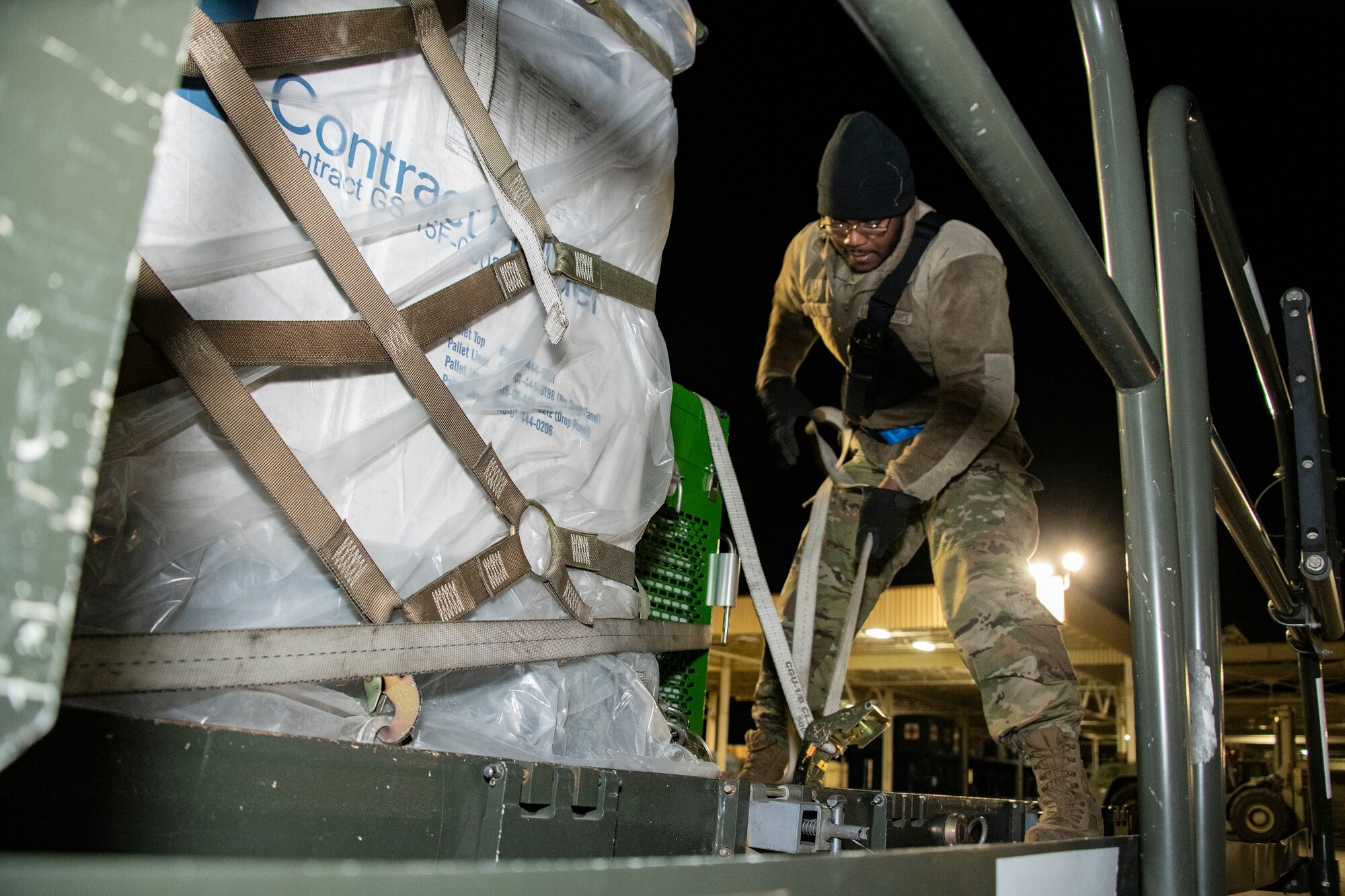 U.S. Air Force Staff Sgt. Rason Bryant, 60th Aerial Port Squadron shift supervisor, secures a pallet to a Tunner 60K aircraft cargo loader during readiness exercise Roundel Perun 22-01, at Travis Air Force Base, California, April 10, 2022.  The base exercise was designed to enhance the capabilities of multiple squadrons in responding to possible real-world events. (U.S. Air Force photo by Heide Couch)