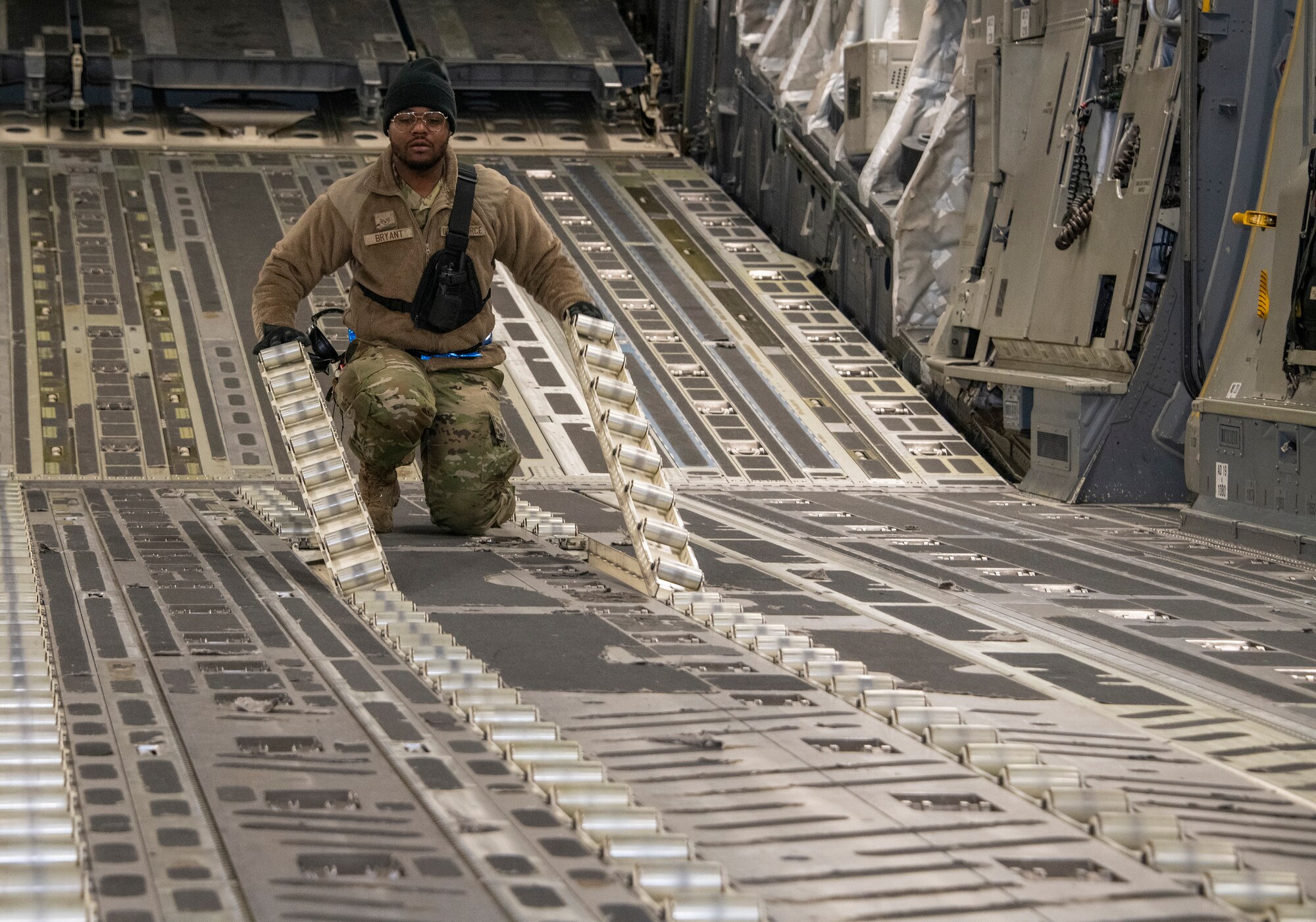an airman moves equipment to load pallets onto an airplane