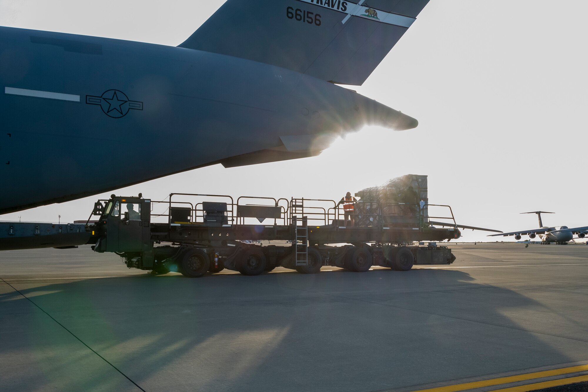 A Tunner 60K aircraft cargo loader delivers cargo to a U.S. Air Force C-17 Globemaster III during readiness exercise Roundel Perun 22-01, Travis Air Force Base, California, April 10, 2022. The base exercise was designed to enhance the capabilities of multiple squadrons in responding to possible real-world scenarios. (U.S. Air Force photo by Heide Couch)