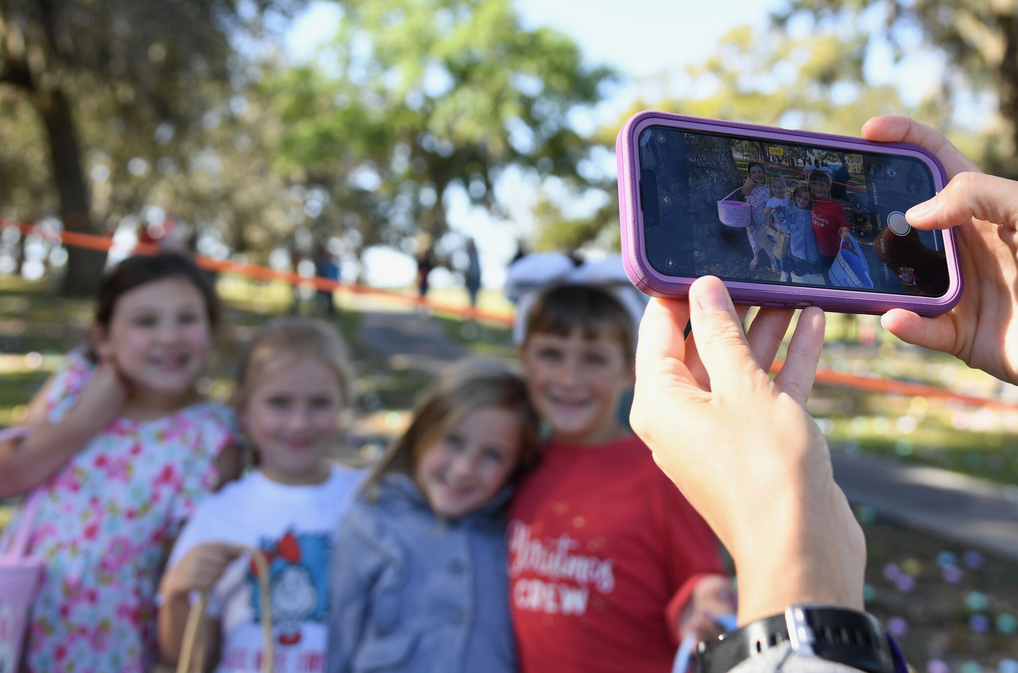 Lisa Crowley, wife of U.S. Air Force Col. Ryan Crowley, 81st Mission Support Group commander, takes a photo of her son and his friends during Keesler's Eggstravaganza at the marina park at Keesler Air Force Base, Mississippi, April 9, 2022. The 81st Force Support Squadron hosted the event for military children. (U.S. Air Force photo by Kemberly Groue)