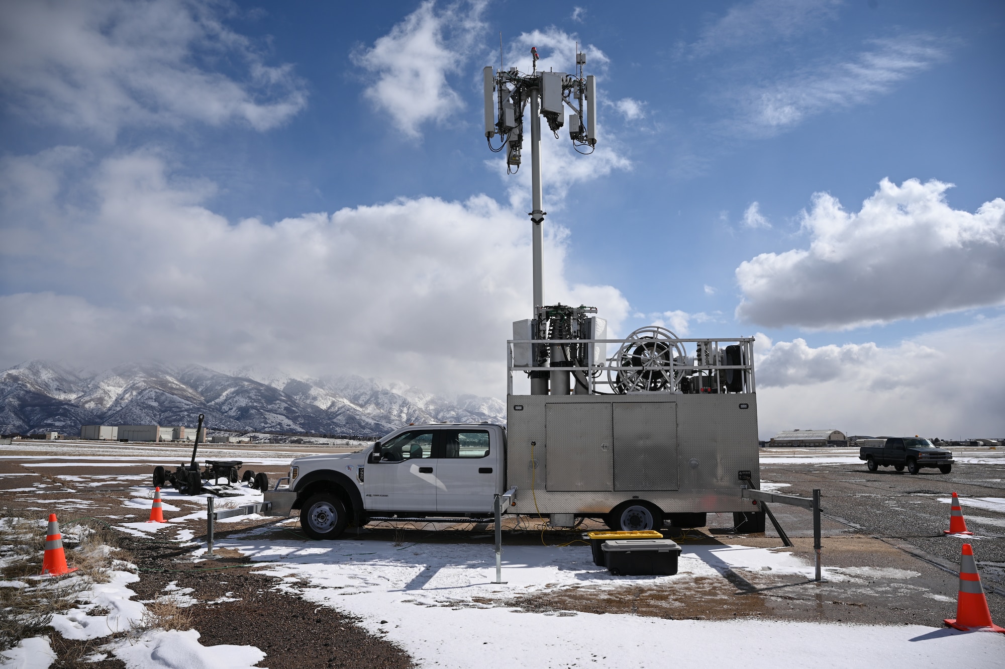 A 5G mobile test station sits on the flight line with the snow-capped Wasatch Mountains in the background.