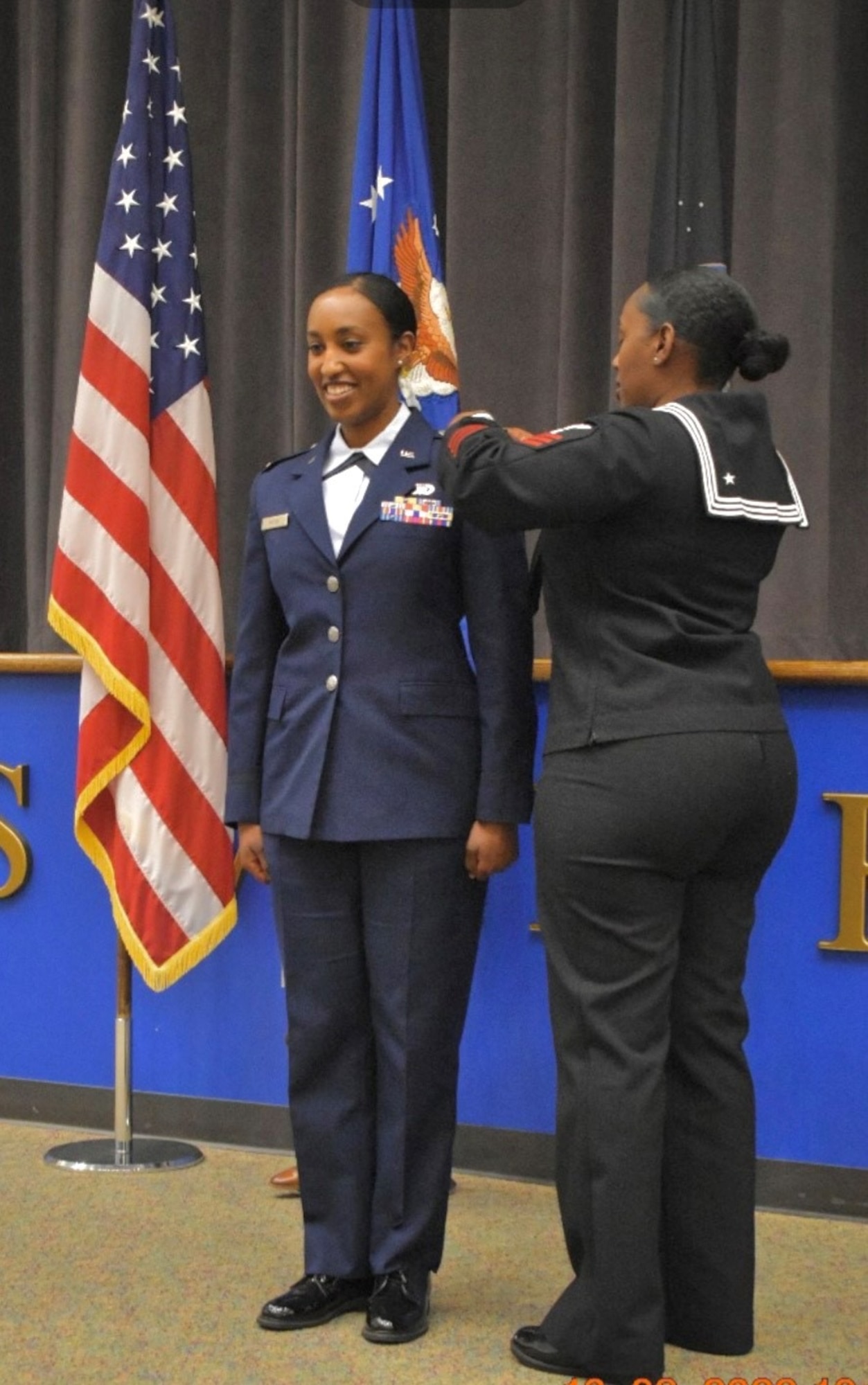 2nd Lt. Mary Andom gets pinned with her new rank by her sister.
