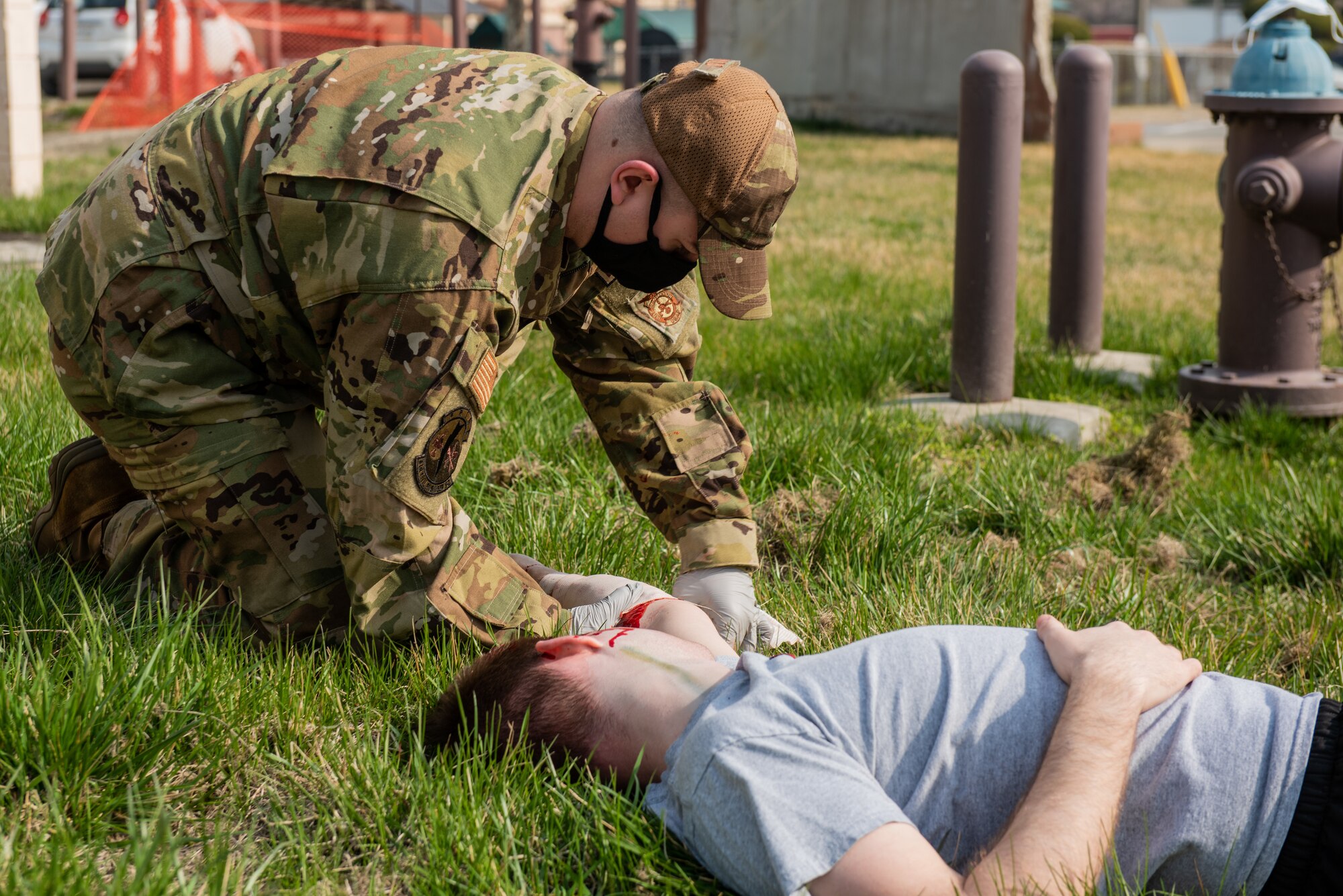 Senior Airman Jonathan Hood, 51st Civil Engineer Squadron fire protection Airman, bandages the arm of a simulated trauma patient during a national registry emergency medical technician training event at Osan Air Base, Republic of Korea, April 5, 2022.