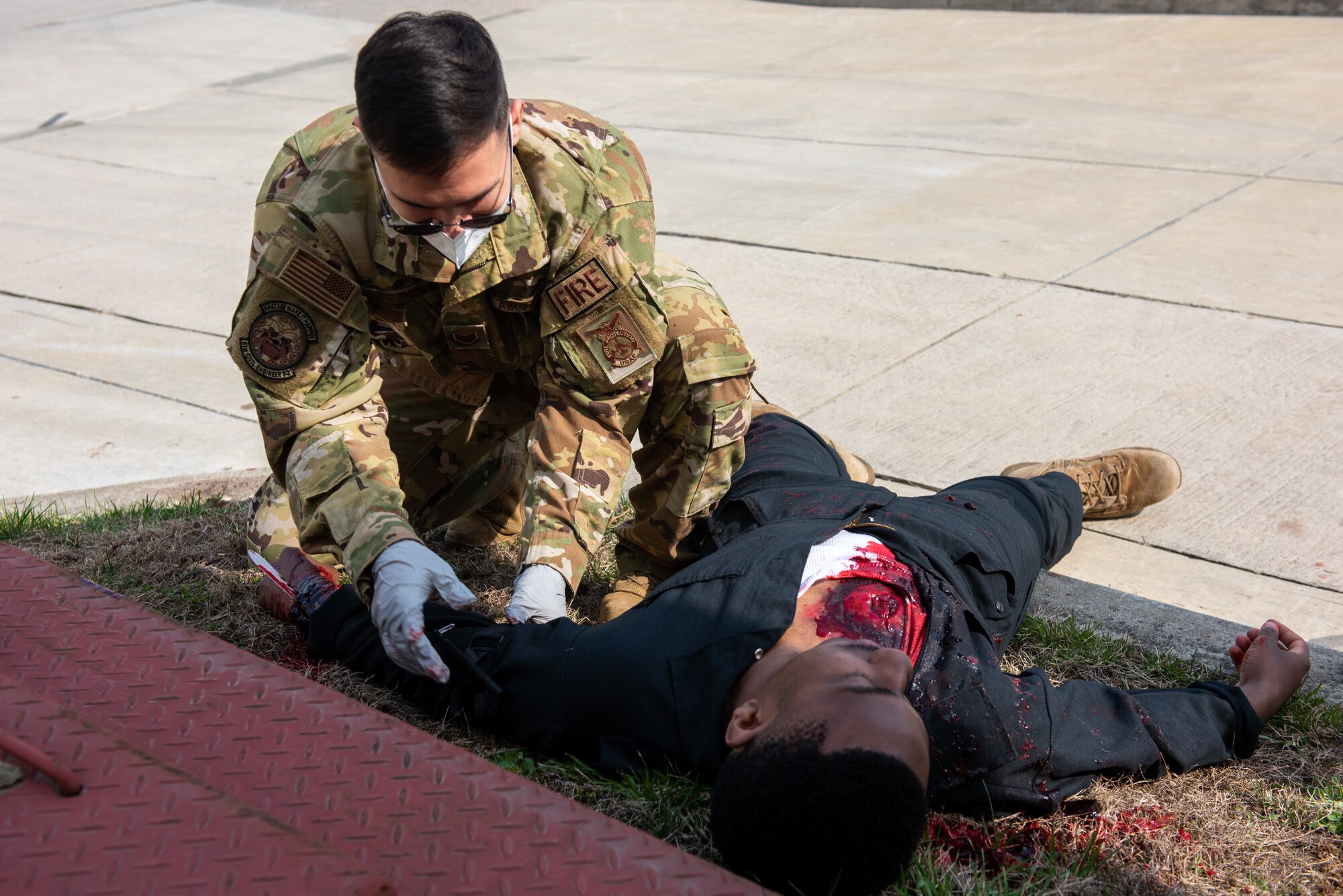 Staff Sgt. Adam Carroll, 51st Civil Engineer Squadron fire protection Airman, applies a quick-clotting bandage to a simulated gunshot wound on Tech. Sgt. Gerard Thomas, 51st Civil Engineer Squadron fire department station chief, during a national registry emergency medical technician training scenario at Osan Air Base, Republic of Korea, April 5, 2021.