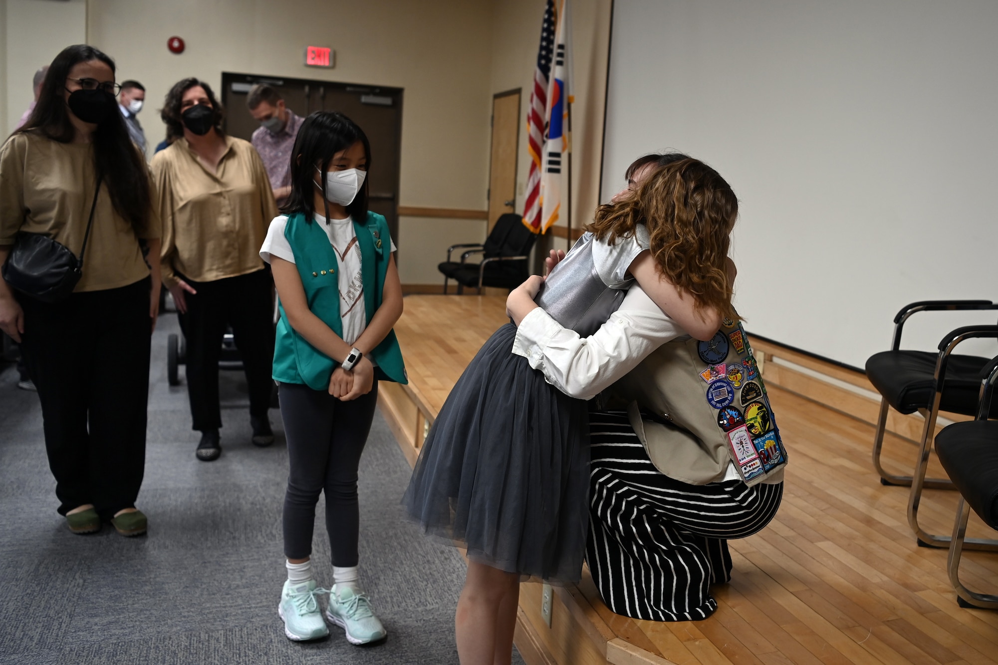 Kate Kinard, daughter of Sam Kinard, 51st Medical Group, and Lt. Col. Jonathan Kinard, Seventh Air Force, hugs a Girl Scout at her Girl Scout Gold Award presentation ceremony April 10, 2022 on Osan Air Base, Republic of Korea. Kinard has been a Girl Scout for more than a decade and credits it with helping her make friends every time she has had to move.  (U.S. Air Force photo by Master Sgt. Rachelle Morris)