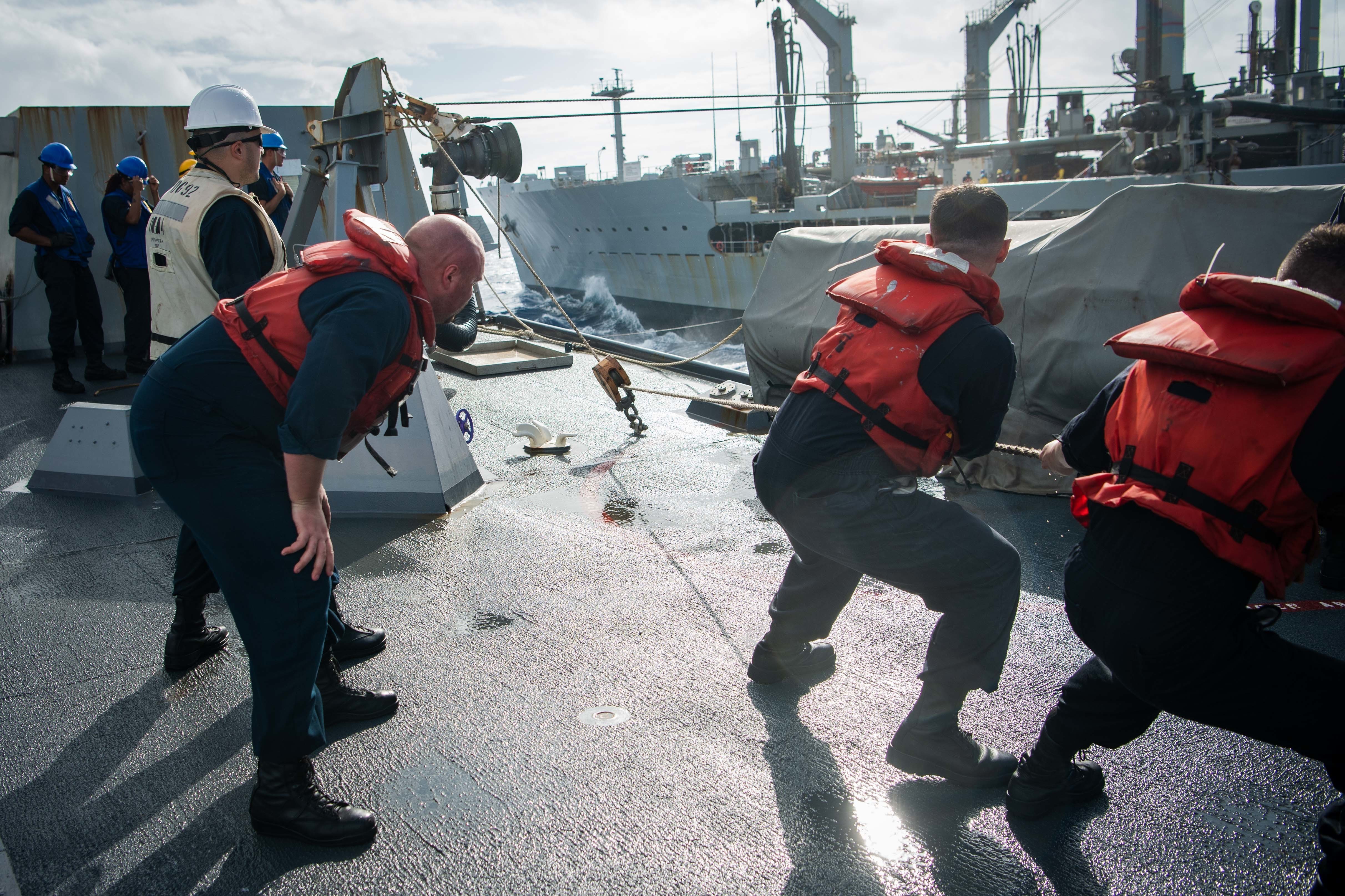 Sailors haul away on a line during a replenishment at sea (RAS) with the Military Sealift Command fleet replenishment oiler USNS Guadalupe (T-AO 200) aboard USS Momsen (DDG 92).