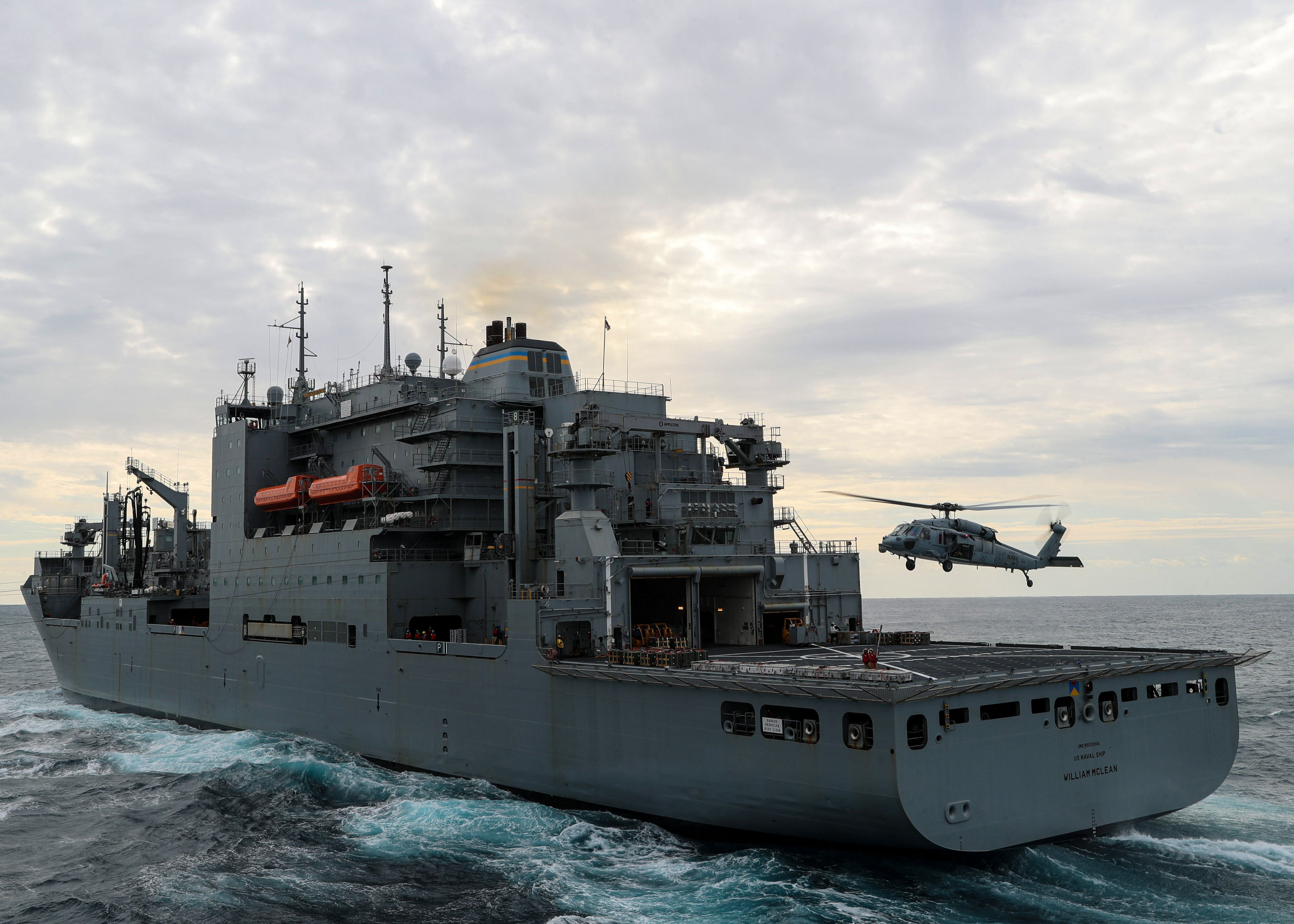An MH-60S Nighthawk prepares to transport ammunition to the aircraft carrier USS Gerald R. Ford (CVN 78) during an ammunition on-load with USNS William McLean (T-AKE 12), April 9, 2022.