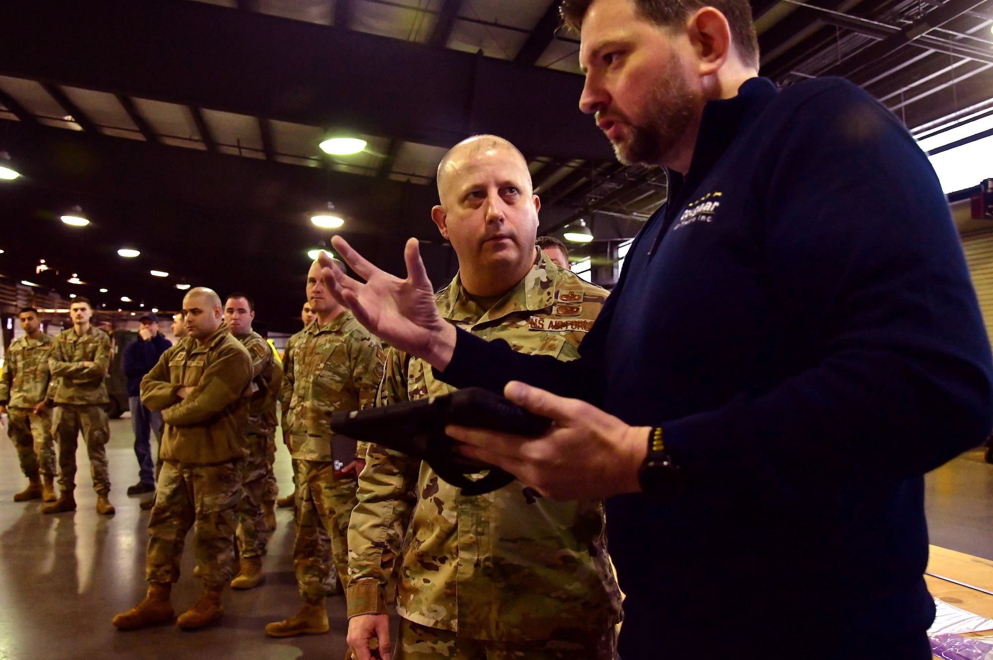 Adam Cutchin, Cougaar Sotware senior software engineer, discusses the Configured Air Load Building Tool with Col. Bary Flack, 436th Maintenance Group commander, April 8, 2022, at Dover Air Force Base, Delaware. The CALBT was developed as part of the "Aerial Port of the Future" initiative to maximize pallet space utilization for cargo processed through the 436th Aerial Port Squadron. (U.S. Air Force photo by Master Sgt. Chuck Broadway)