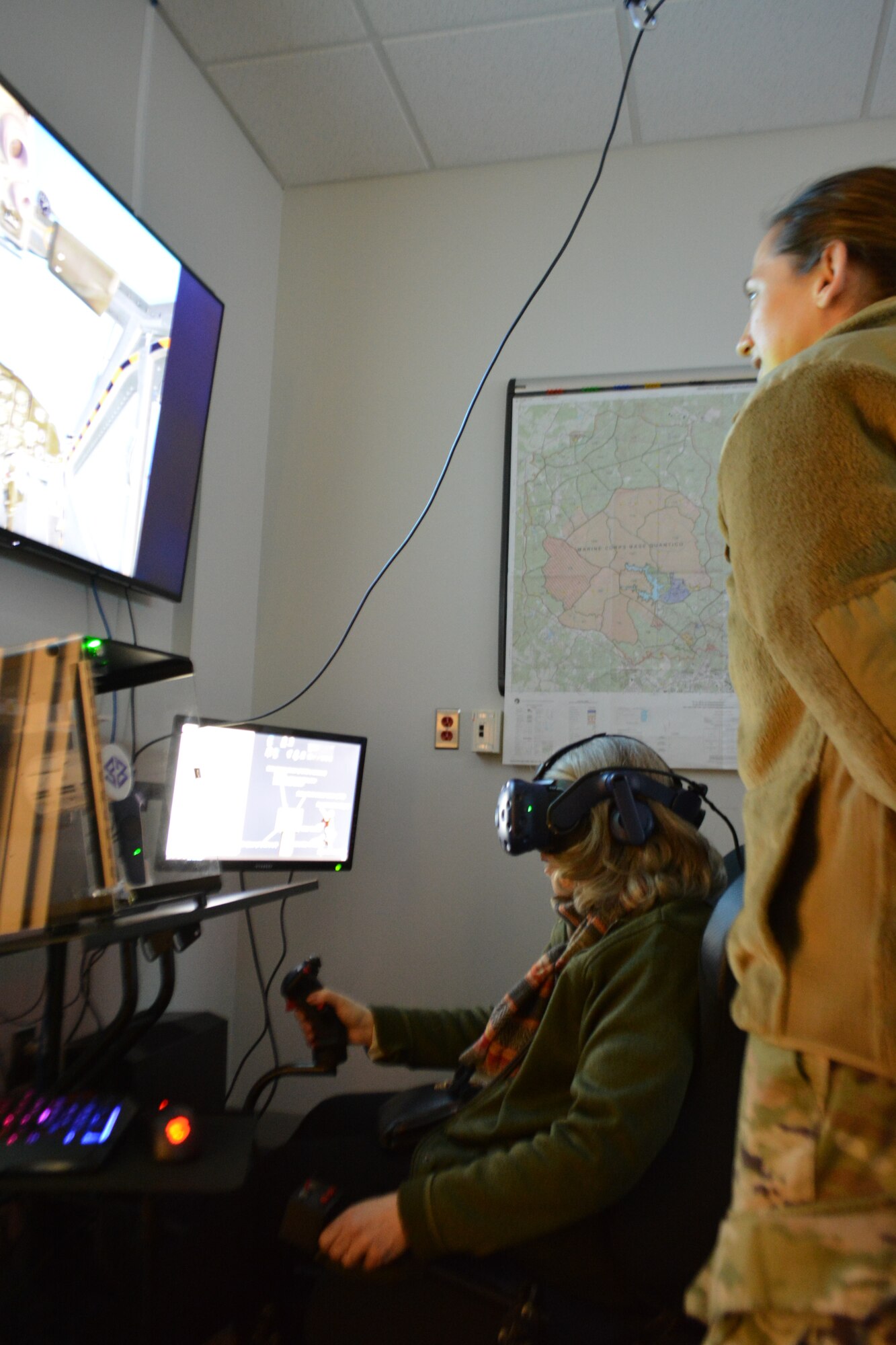 Mrs. Lisa Smith, Bowie Business Innovation Center executive director, “pilots” a helicopter in a virtual reality lab UH-1N Huey cockpit during the Honorary Commanders Program quarterly visit at Joint Base Andrews, Md., April 4, 2022.