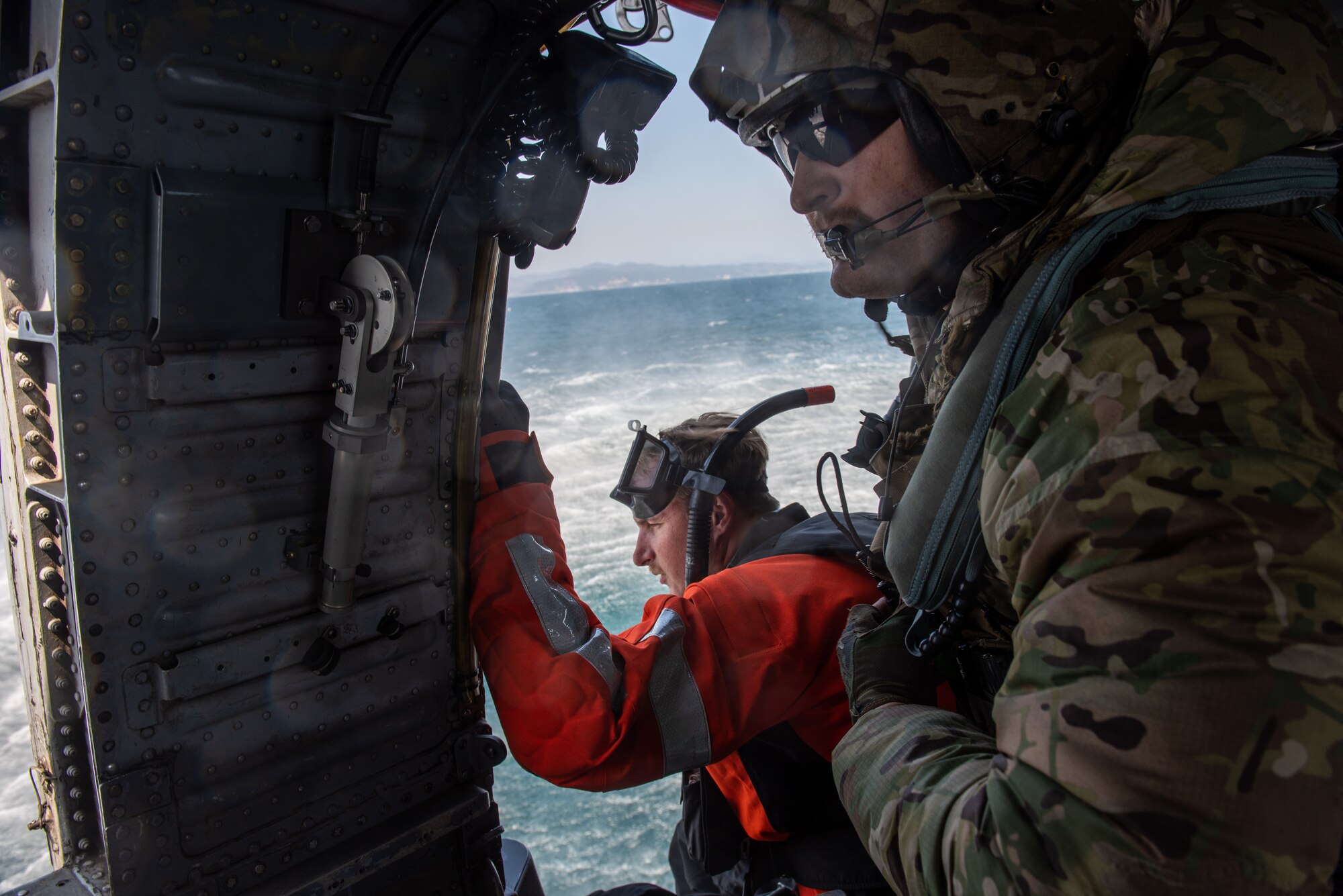 Naval Aircrewmen (Helicopter) 1st Class Joshua Armitage, Helicopter Sea Combat Squadron 85 rescue swimmer, and Ryan Kuiper, Helicopter Sea Combat Squadron 85 crew chief, prepare for an open-sea rescue during a combat search and rescue training event April 8, 2022 over the Pacific Ocean.