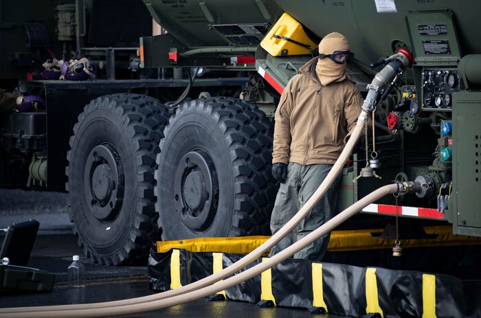 Steelworker Constructionman Austin Leisure, a native of Hillsboro, Illinois, assigned to Navy Cargo Handling Battalion (NCHB) 1, monitors a fuel line during a fixed wing refueling operation.