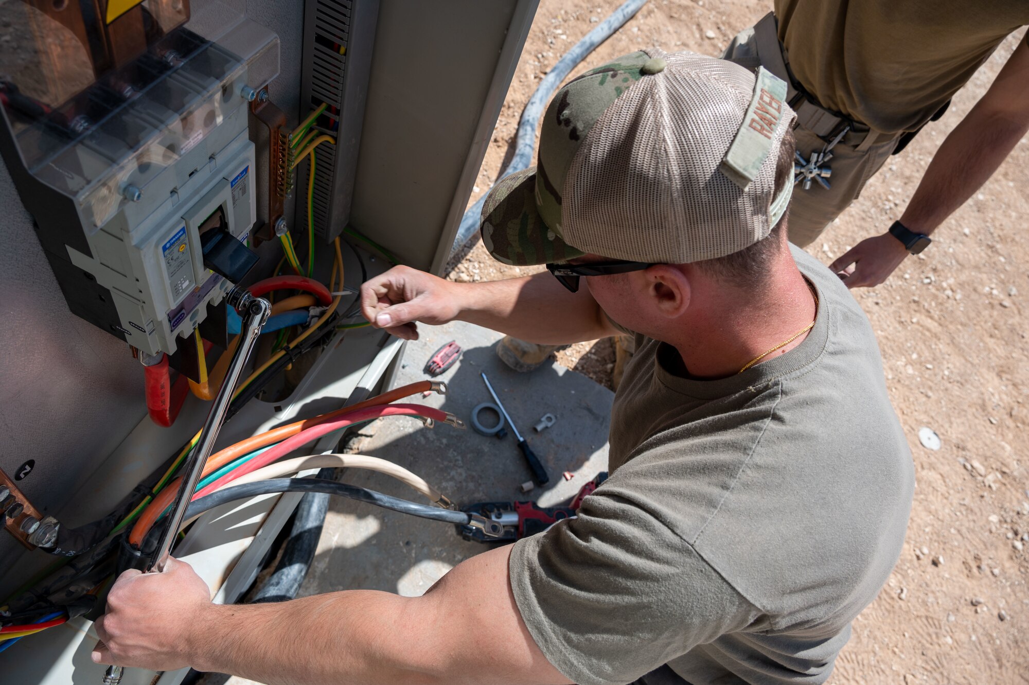 U.S. Air Force Airman 1st Class Joshua Rayer, 332d Expeditionary Civil Engineer Squadron electrical technician, installs electrical cables for a new a backup generator at an undisclosed location in Southwest Asia, March 28, 2022. The 332d ECES provides, operates, and maintains a sustainable installation through engineering and emergency response services across the full mission spectrum. (U.S Air Force photo by Tech. Sgt. Lauren M. Snyder)