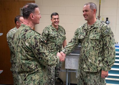 (left) Commander of Naval Sea Systems Command (NAVSEA) Vice Adm. Bill Galinis greets Naval Surface Warfare Center Panama City Division's 2021 Sailor of the Year Navy Diver First Class (ND1) Cody Levins during his NSWC PCD visit, March 30. (center) Capt. David Back, NSWC PCD commanding officer, said Levins' efforts directly supports mission critical NAVSEA projects, including the Q-20C towed mine hunting sonar, Seal Delivery Vehicle operations, and MK18 MOD 2 Kingfish target identification. (U.S. Navy photo by Eddie Green)