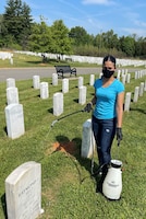 Spc. Nicole Mota cleans graves