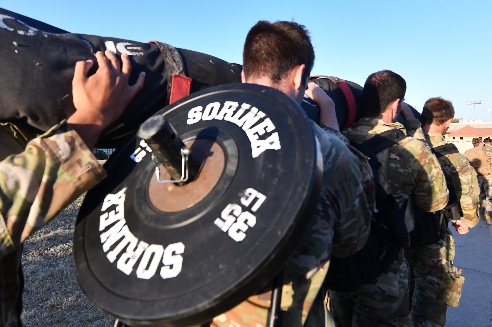 Special Warfare Trainees participate in the Special Warfare Training Wing rededication ceremony in honor of U.S. Air Force Lt. Col. William Schroeder and U.S. Air Force Staff Sgt. Scott Sather at the SWTW training compound Joint Base San Antonio, Chapman Training Annex, Apr. 8, 2022. The wing hosted a two and one-half mile ruck march followed by Memorial pushups and the unveiling of refitted memorials in coordination with Gold Star families.  (U.S. Air Force photo by Brian Boisvert)