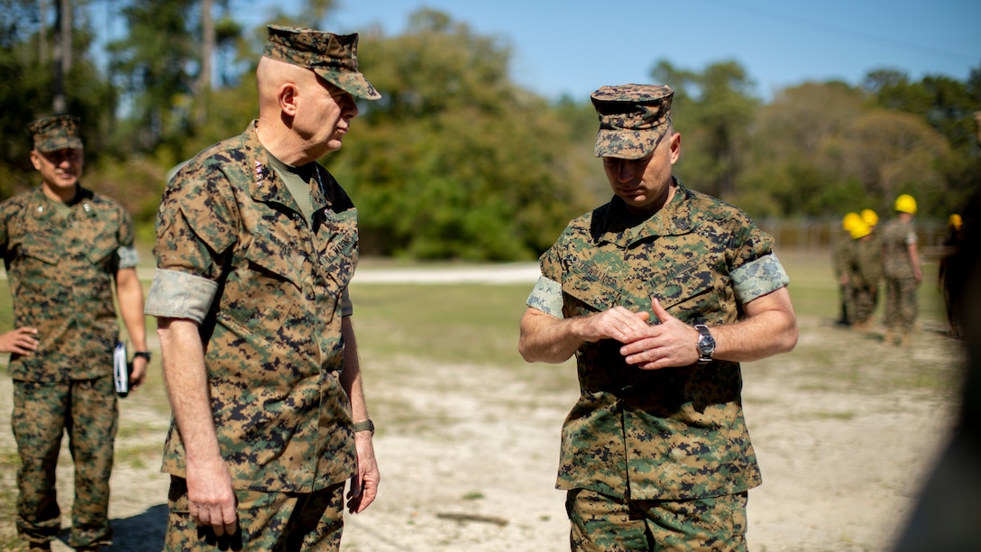 U.S. Marine Corps Gen. David Berger, commandant of the Marine Corps, speaks with Master Gunnery Sgt. Gregory Terwilliger, explosive obstacles and hazards division chief, at Marine Corps Engineer School on Marine Corps Base Camp Lejeune, North Carolina, March 28, 2022.