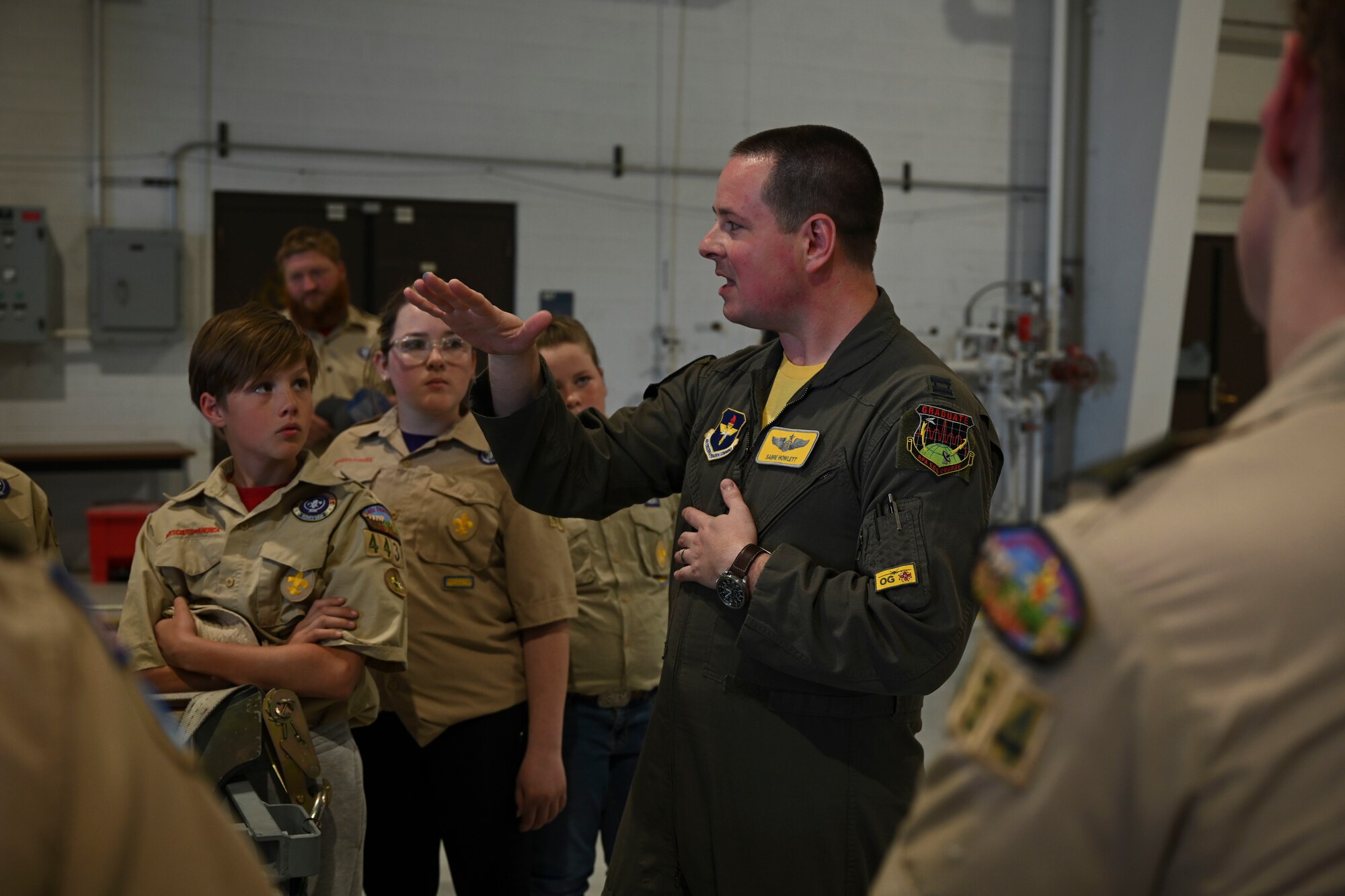 Capt. Evan Howlett, 49th Operations Group executive officer and MQ-9 evaluator pilot, answers the scouts questions about the MQ-9 Reaper during a base tour, April 1, 2022, on Holloman Air Force Base, New Mexico. Static displays were set up in hangar 294, giving the troops a chance to take a closer look at an MQ-9 Reaper and F-16 Vipers. (U.S. Air Force photo by Airman 1st Class Antonio Salfran)
